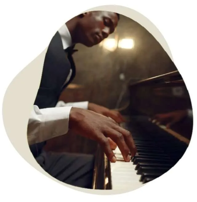 Pianist playing a song on a grand piano under warm stage lights