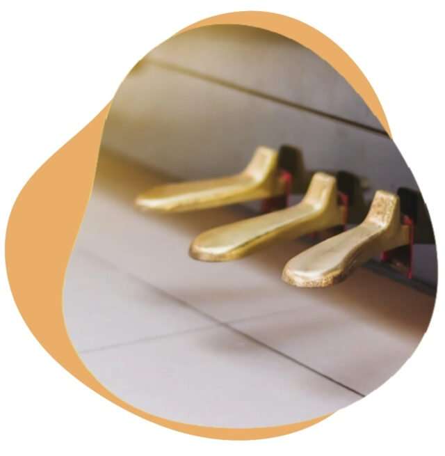 Three gold pedals at the base of a piano